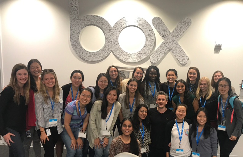 A group of students pose for a picture in front of the 'box' logo