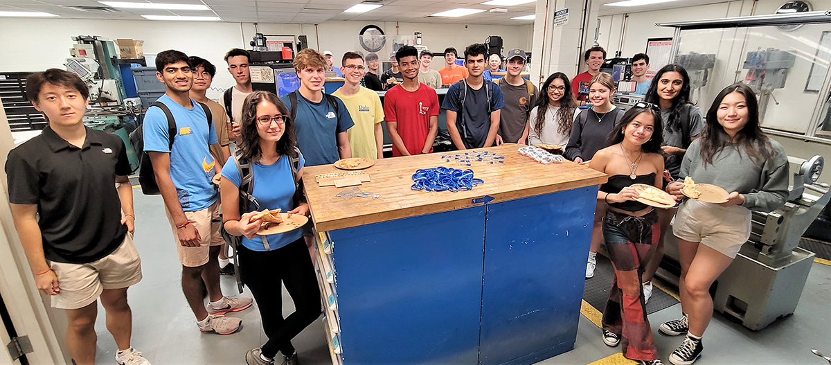 a group of students pose in a line in a machine shop
