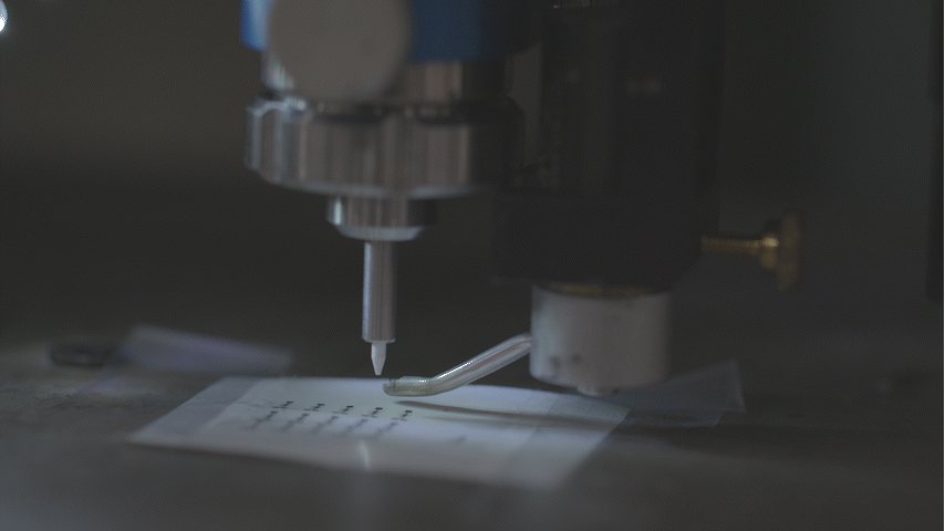 A moving gif of an ink-jet printer moving quickly over a piece of paper