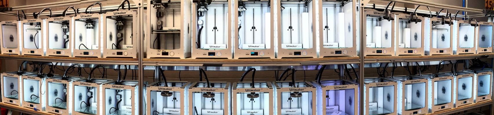 rows of 3D printers line a wall of the Innovation Co-Lab