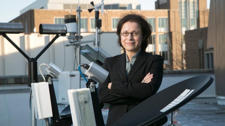 Ana Barros, professor of civil and environmental engineering, stands at a weather station that her students installed on top of the Fitzpatrick Center Ana Barros with weather station