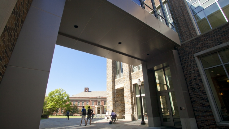 View of Hudson Hall, the home of the Thomas Lord Department of Mechanical Engineering & Materials Science at Duke, as seen through a walkway arch of the nearby Fitzpatrick Center.
