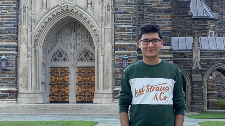 A young man standing in front of the Duke Chapel