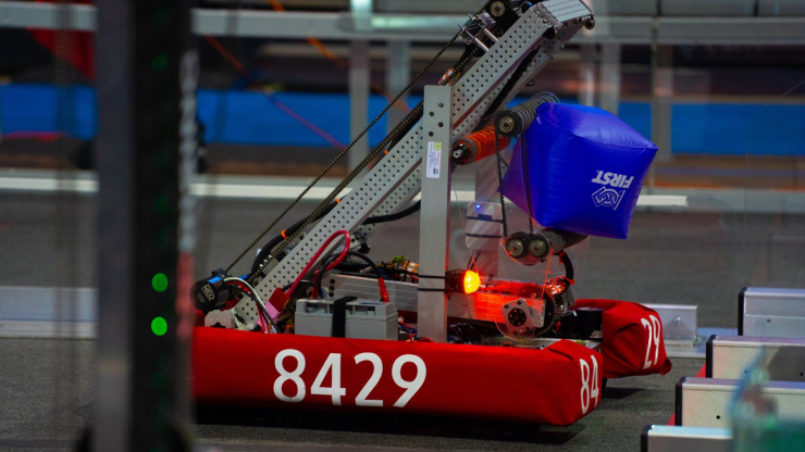 Robot from team 8429 picks up a cube at the FIRST Robotics Competition