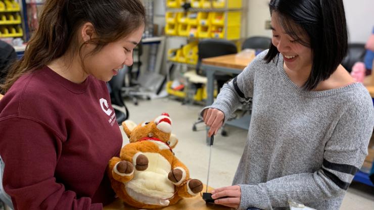 Two students work to fix a stuffed animal with electronics