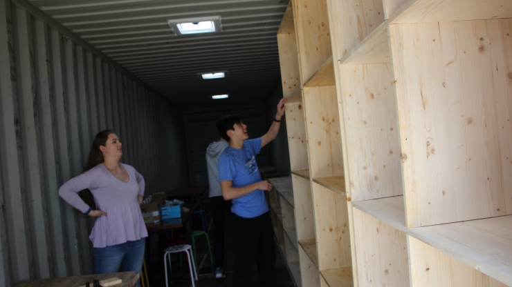 Students in the spring semester of Design 101 move shelves into a storage container, which will become a functioning design space. The team was recognized at the Global Innovation Challenge for their project. 