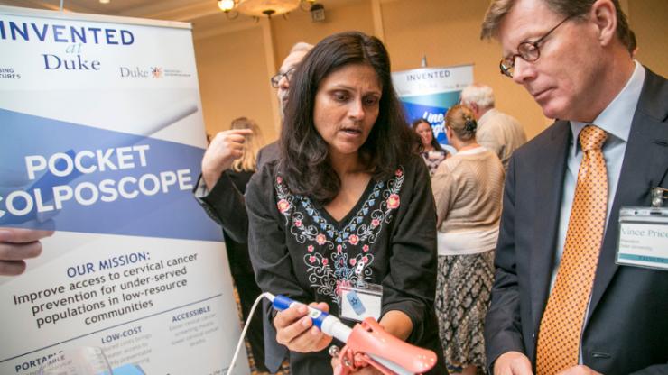 BME’s Nimmi Ramanujam demonstrates the Pocket Colposcope to Duke University President Vincent Price. The invention is a low-cost device that helps screen for and diagnose cervical cancer.