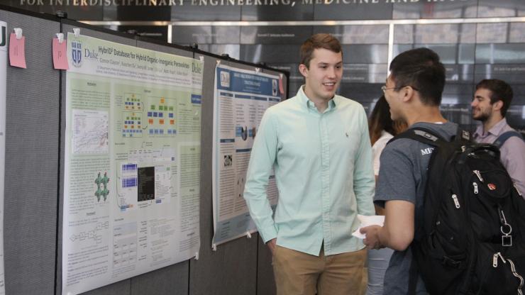 Clayton Connor answers questions at the Duke REU poster session held in Fitzpatrick Hall