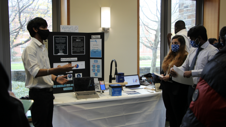 A student displays their automated faucet design project during the Managing Product Design 