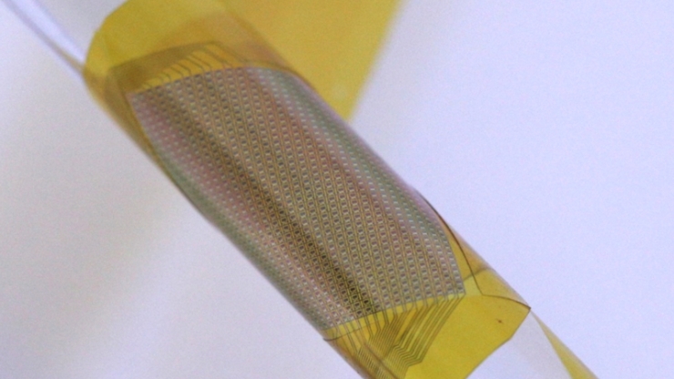 A yellow patch of microelectronics wrapped around a thin glass tube