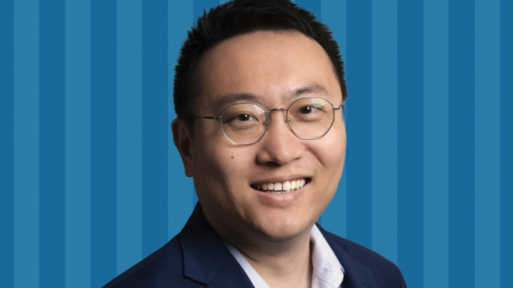 Harry Wang headshot in front of a blue striped background