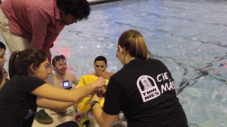 A team in EGR 190 gathers poolside with its submersible robot