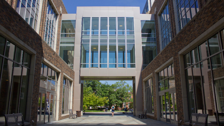 A two-story, windowed crosswalk between two buildings on a college campus
