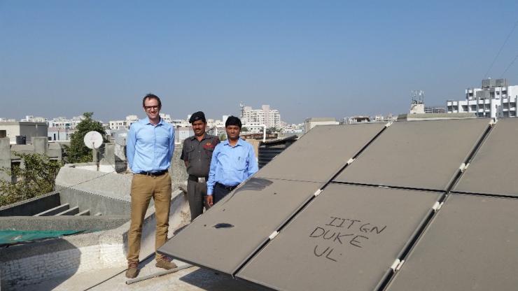 Duke engineering professor Michael Bergin (left) stands with Indian Institute of Technology-Gandhinagar colleague Chinmay Ghoroi (right) next to that university’s dusty solar panel array