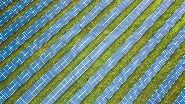 an aerial photo of a field of many rows of solar energy arrays
