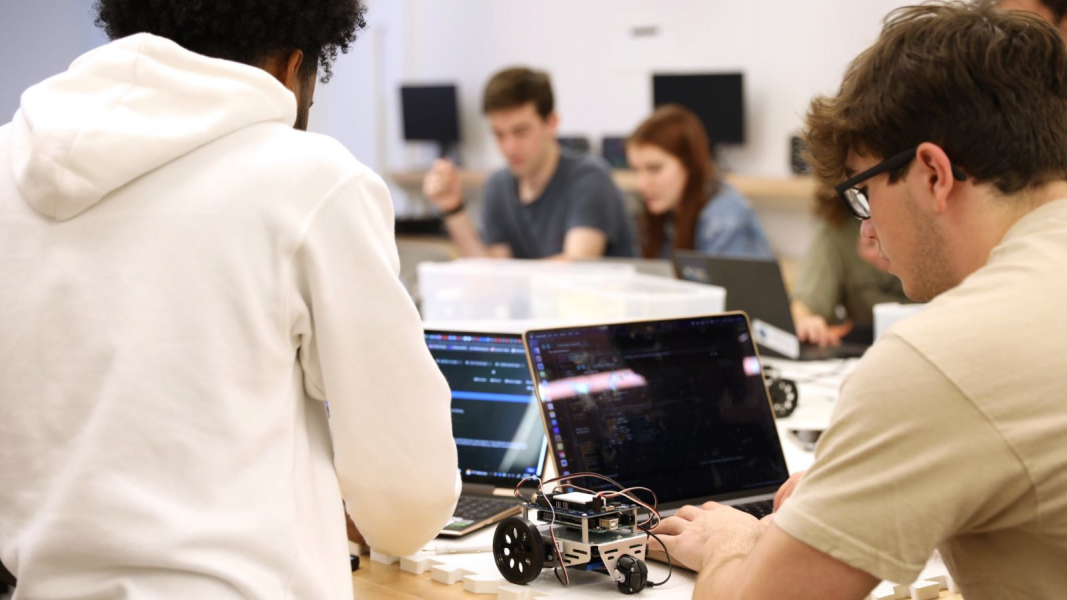 Students in an early lab pore over laptops as they learn to build their bots