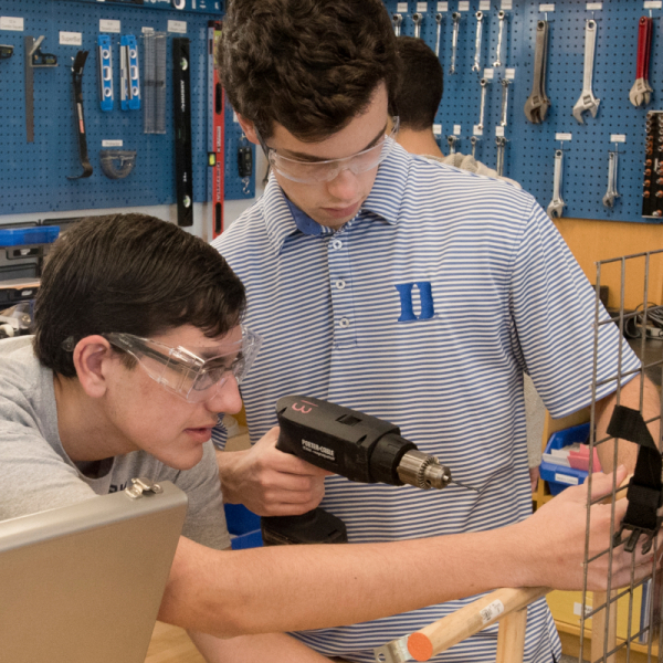 Two Duke University engineering students use a power drill