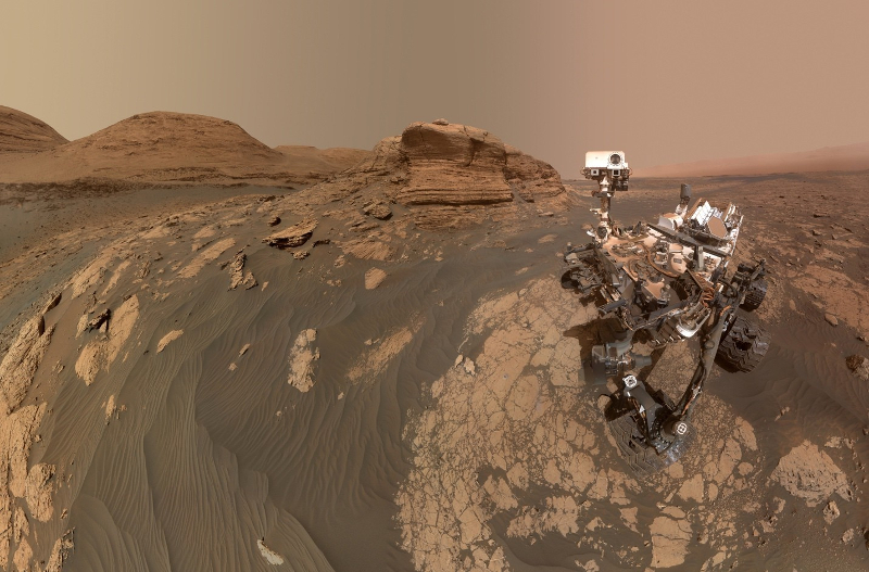 A complex robot on a red, rocky landscape