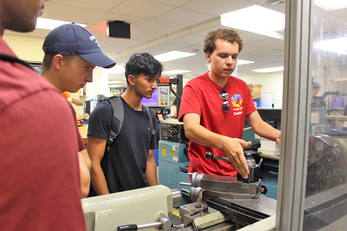 students work on a machine