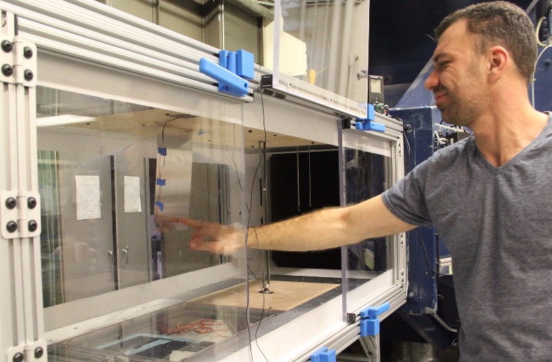 Dani Levin adjusts piezoelectric device in Duke's wind tunnel