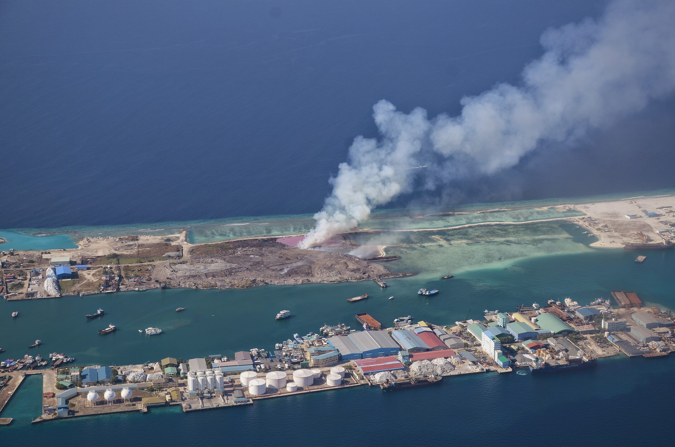 Aerial view of Thilafushi island with a trash burning plume visible