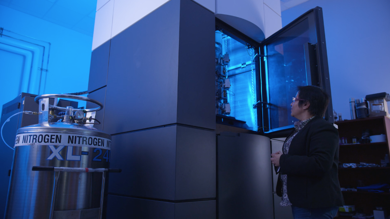 A woman stares up into a giant box with a soft blue light inside