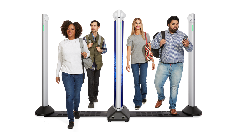Several people walking through a scanning device consisting of small walls