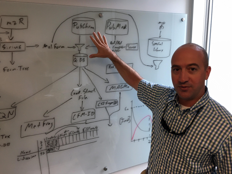 Lee Ferguson standing at a white board with an engineering schematic drawn on it