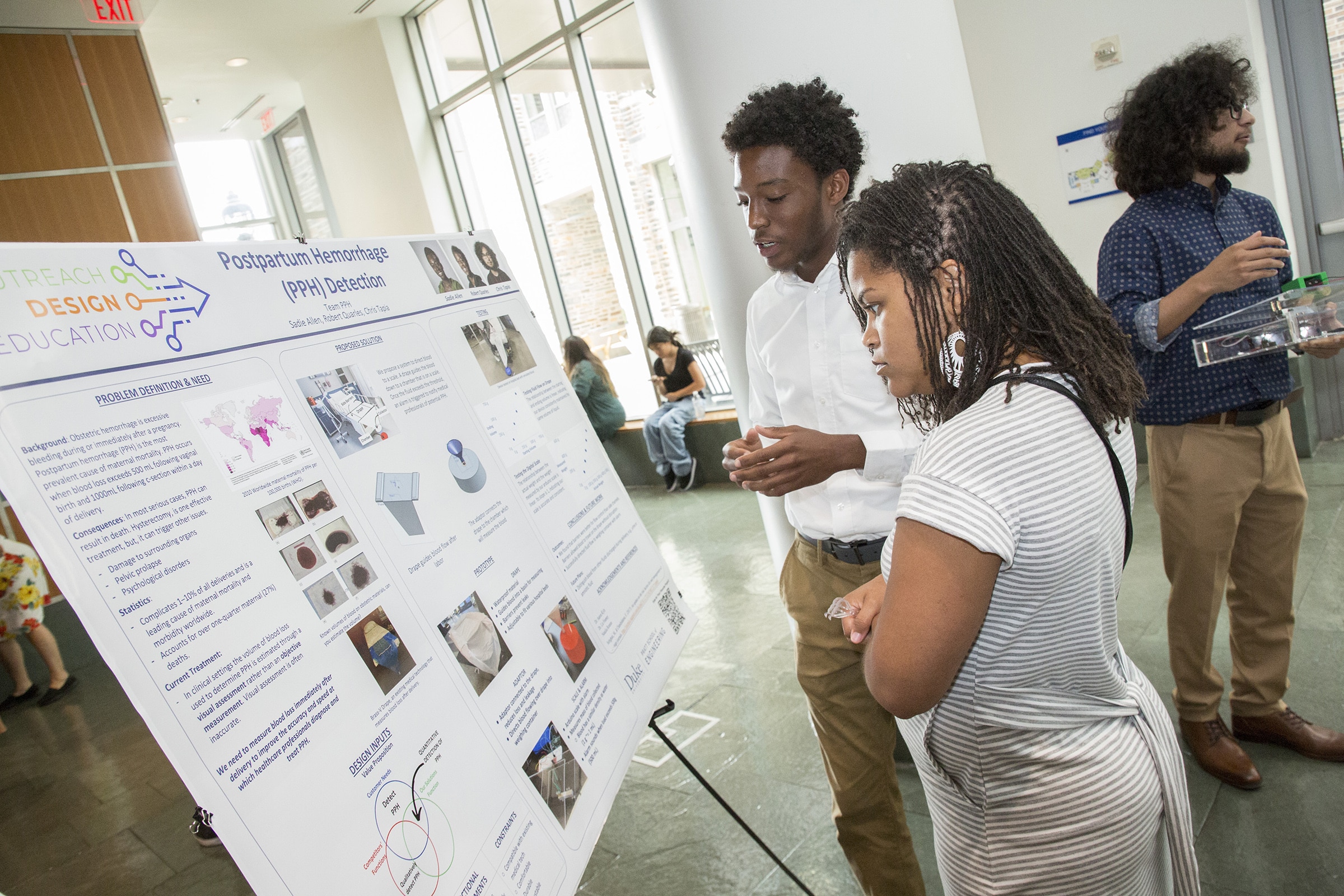 two people look at a research poster