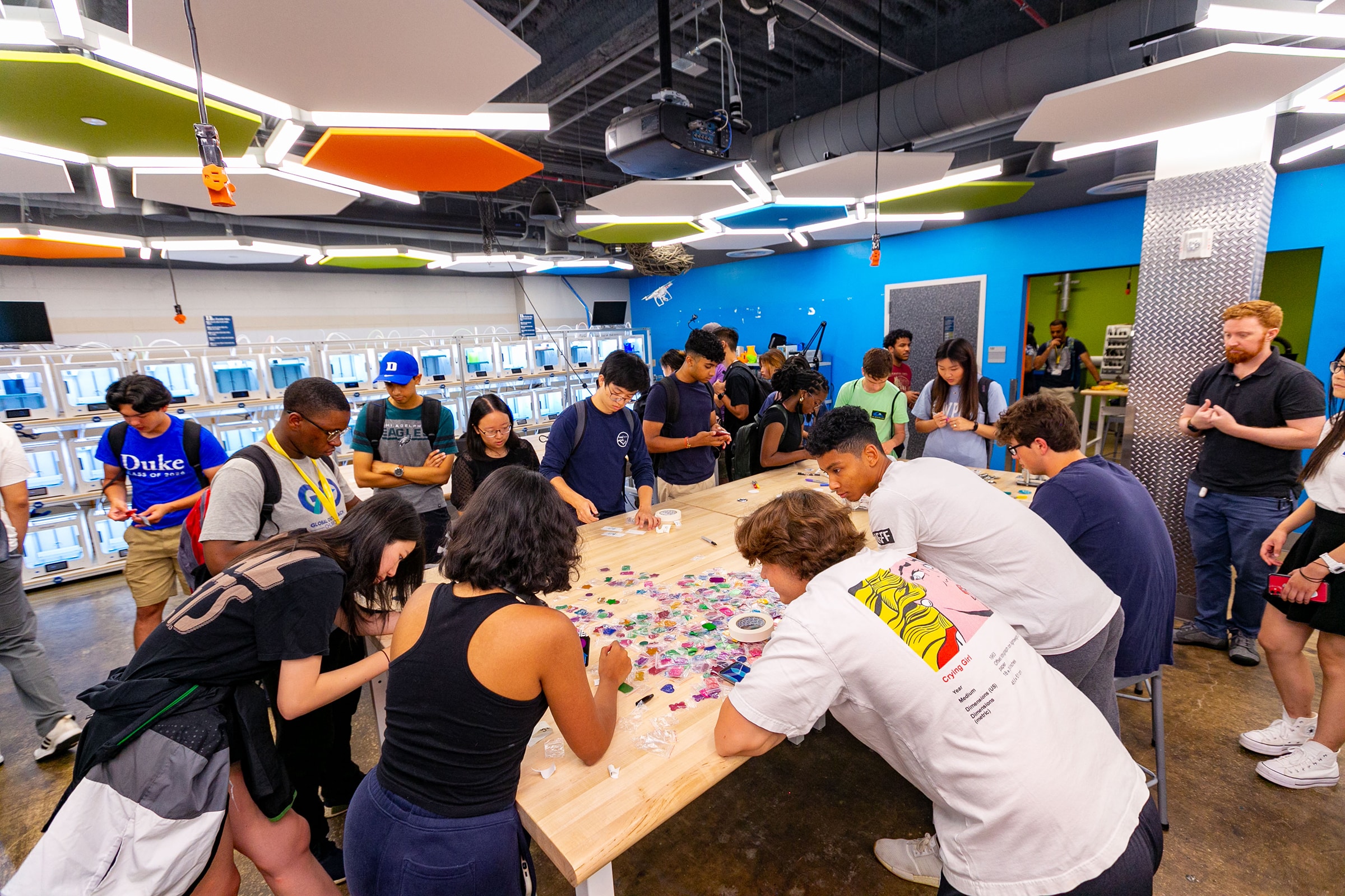 First-year students participating in Project Seed, an Experiential Orientation program for incoming students, use a laser cutter at the Co-Lab to create designs.