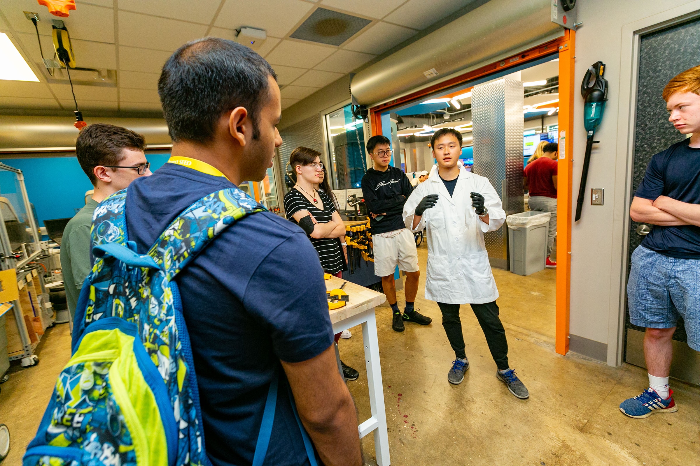 First-year students participating in Project Seed, an Experiential Orientation program for incoming students, use a laser cutter at the Co-Lab to create designs.