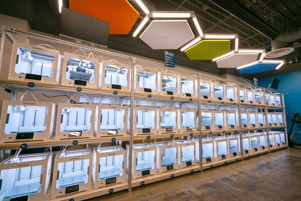 First-year students participating in Project Seed, an Experiential Orientation program for incoming students, use a laser cutter at the Co-Lab to create designs.