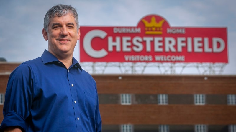 Man standing in front of a building with a Chesterfield sign on top