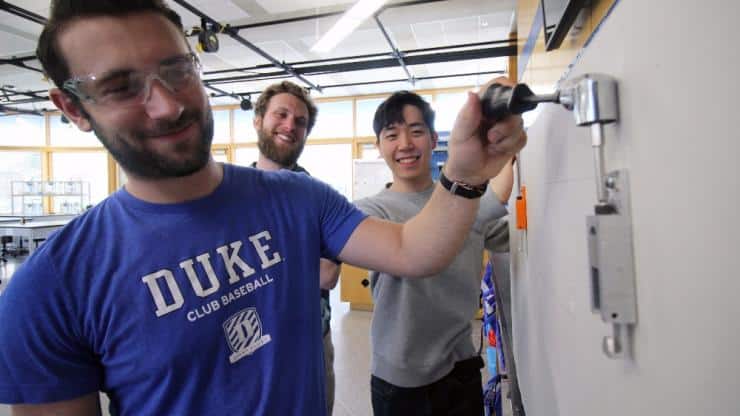 Duke students show off their adjustable wall hook for art galleries.