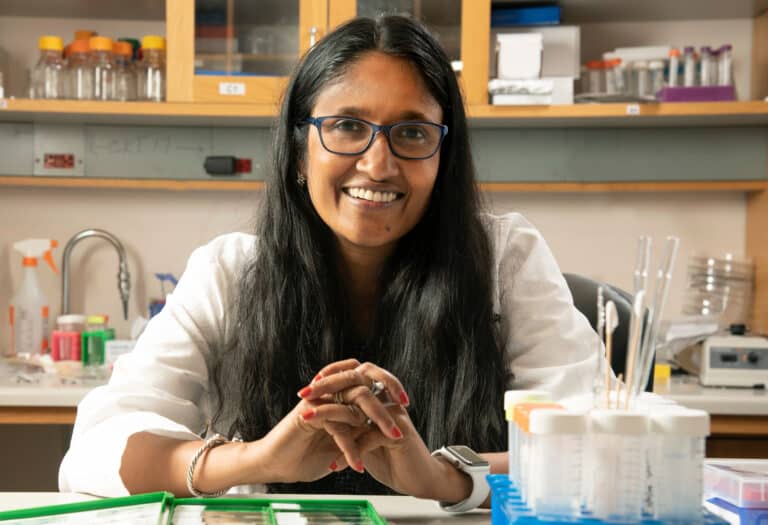 woman in lab coat at wet lab bench