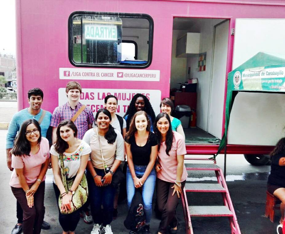 group of women students posing outside of a pink trailer