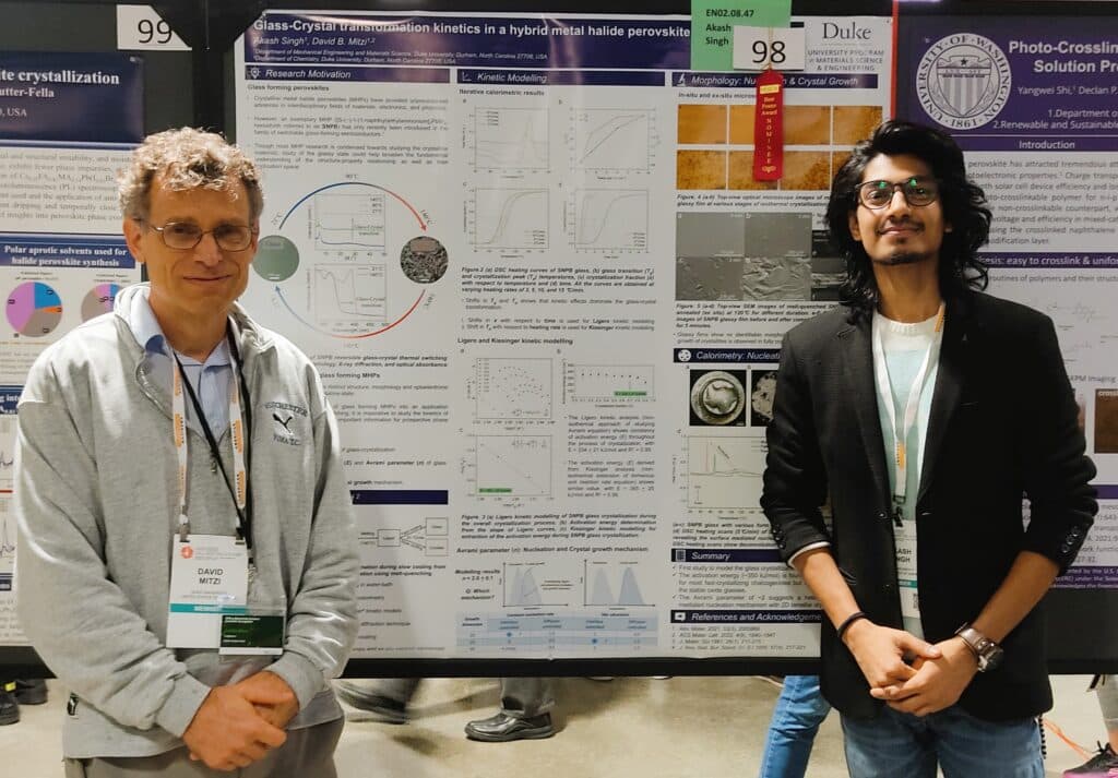 Two researchers in front of poster presentations on glassy perovskites at MRS Fall Meeting and Exhibit, Boston, 2022
