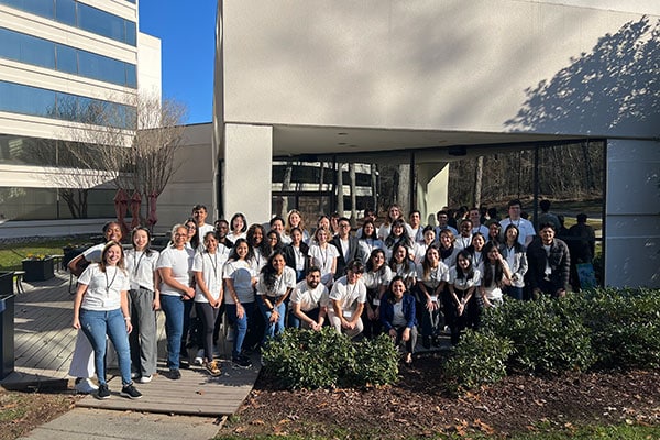 a group of students posed together in front of a white building