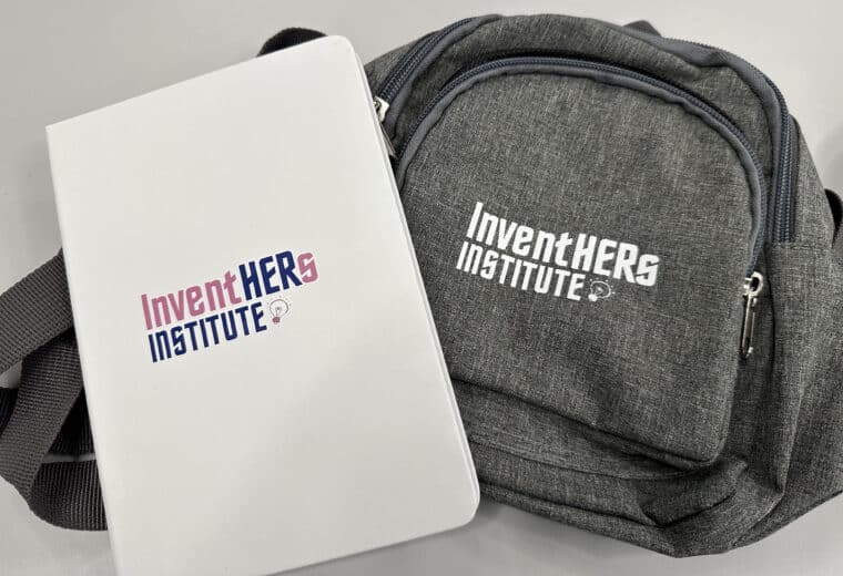 a folder and bag with InventHERs Institute logo