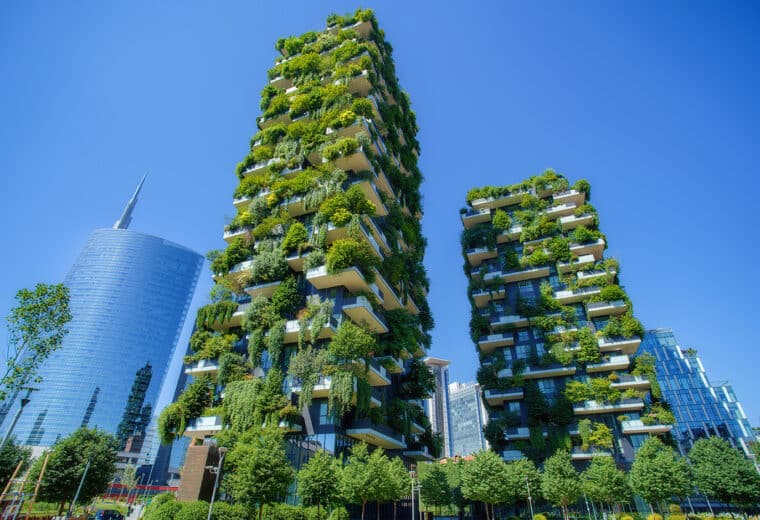 two skyscrapers covered in plants and trees