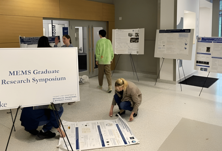 students prepare research posters for symposium event