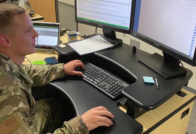 man in military fatigues at a computer