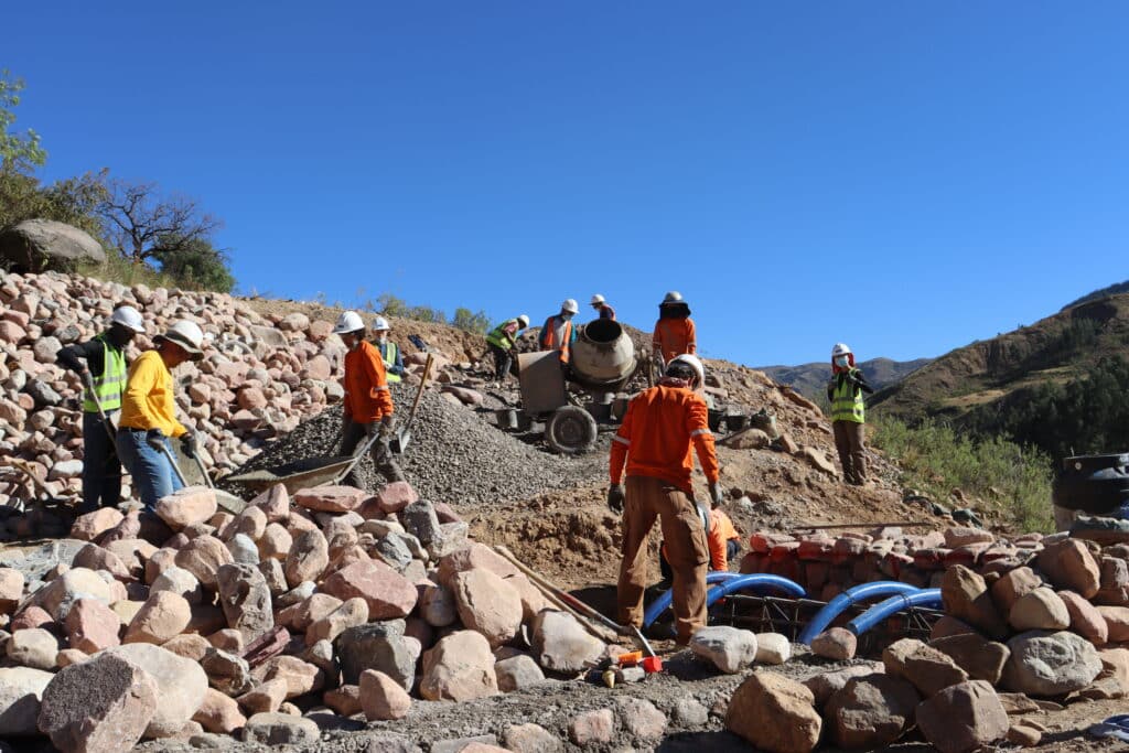 group of people in hardhats walking around large stones