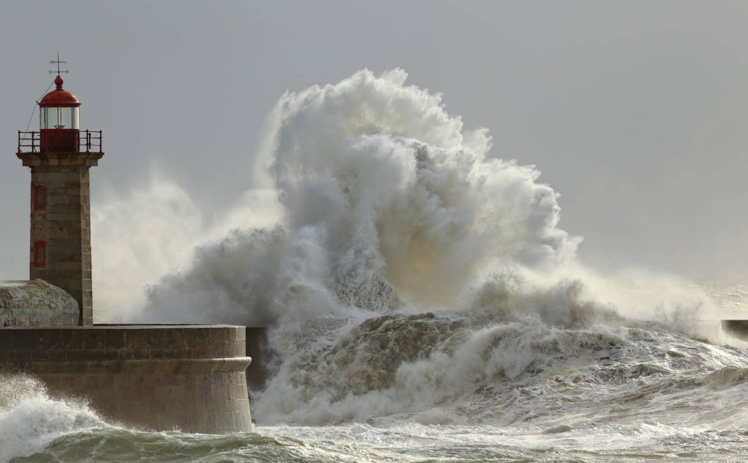 wave crashes against a lighthouse