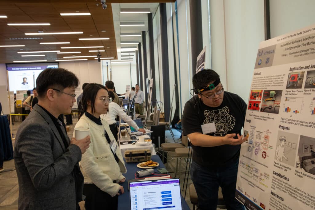 a person points to a research poster while two people listen