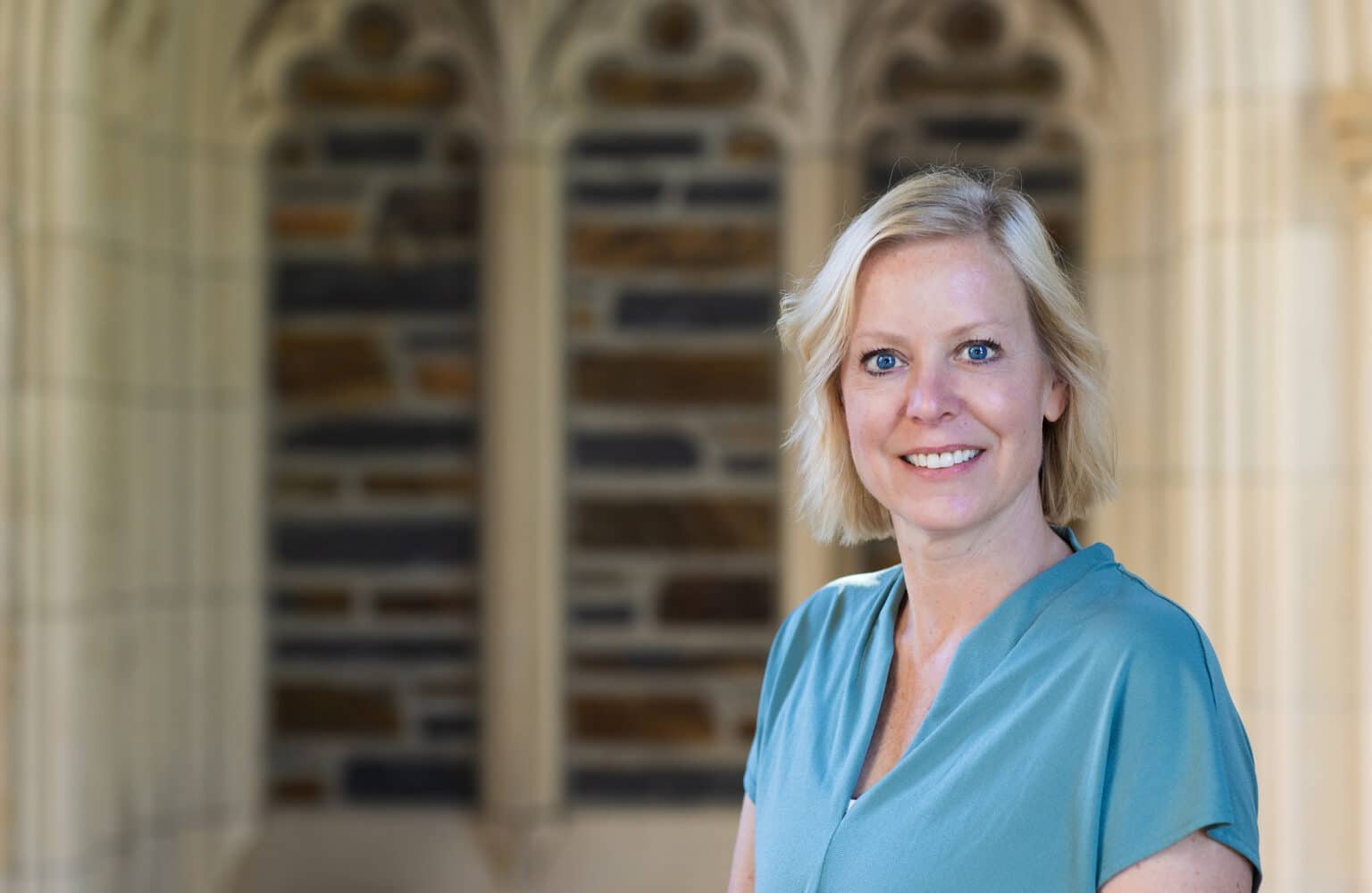 Christy Bozic poses in a blue blouse outside of Duke Chapel.