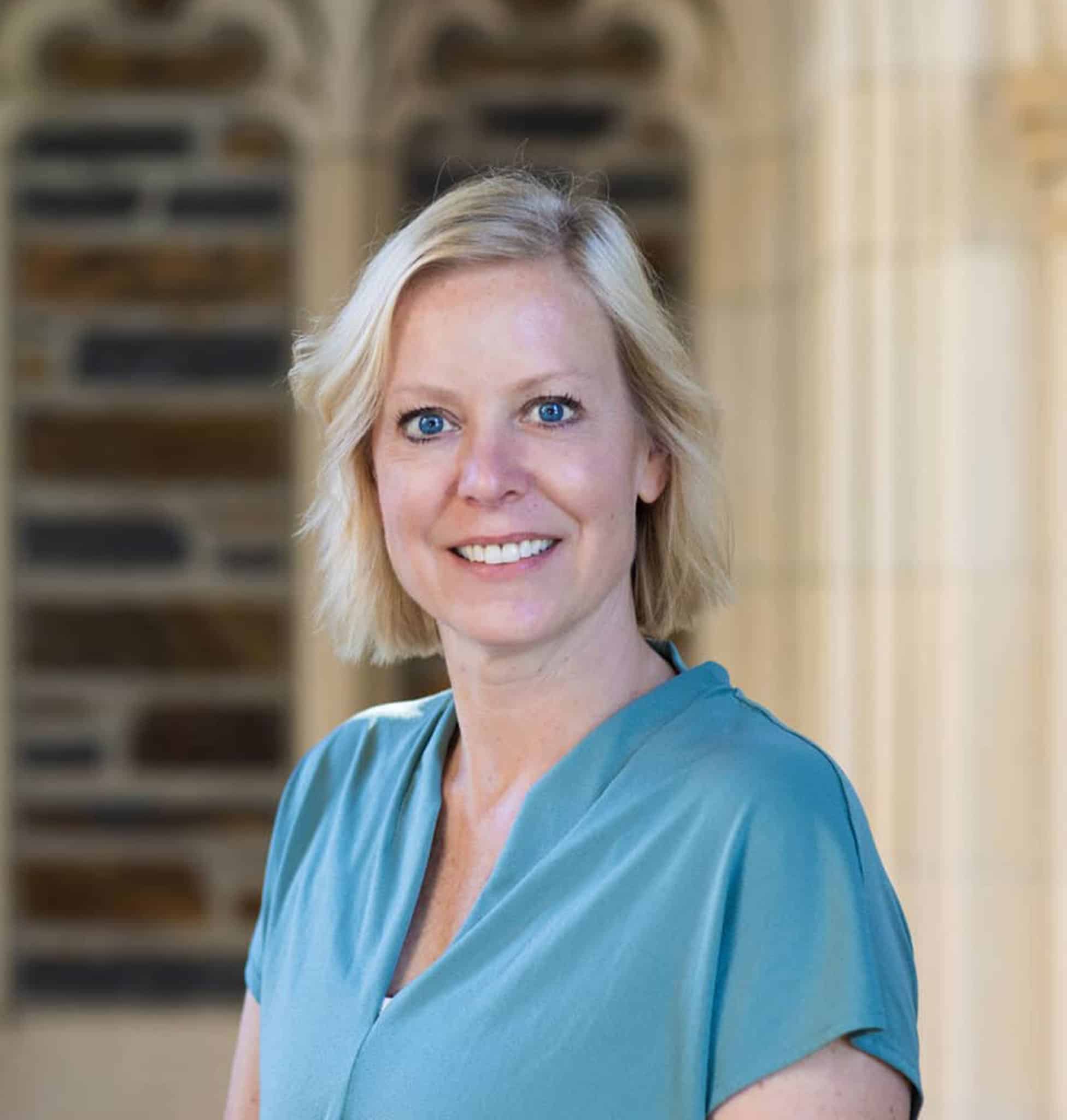 Christy Bozic poses in a blue blouse outside of Duke Chapel.