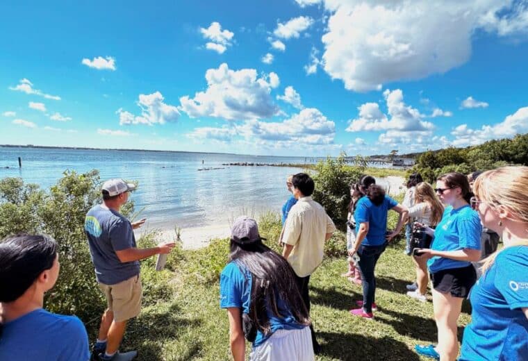 students standing and talking on the coastline