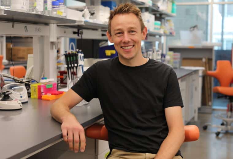 John Hickey poses in his lab after receiving the NSF CAREER AWARD
