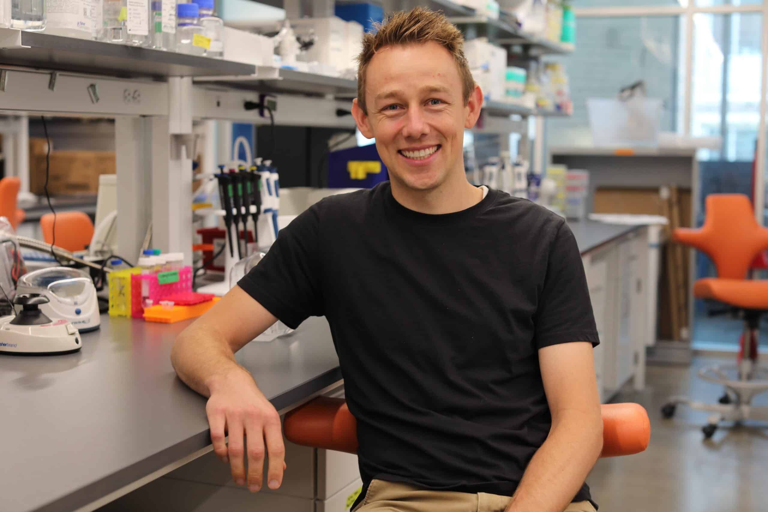 John Hickey poses in his lab after receiving the NSF CAREER AWARD